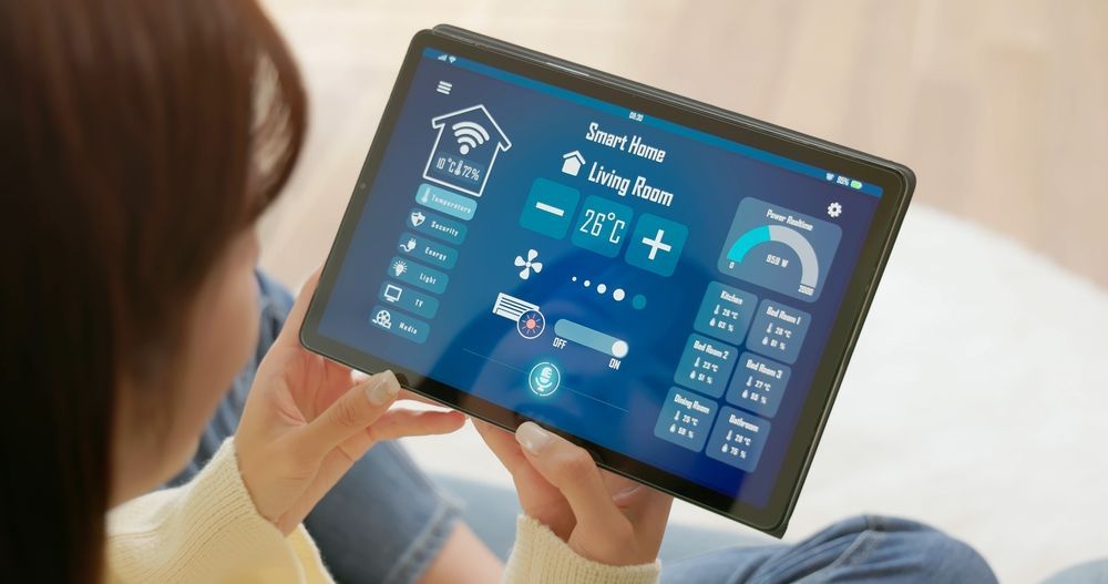 Person using a tablet showing a smart home control dashboard in a living room