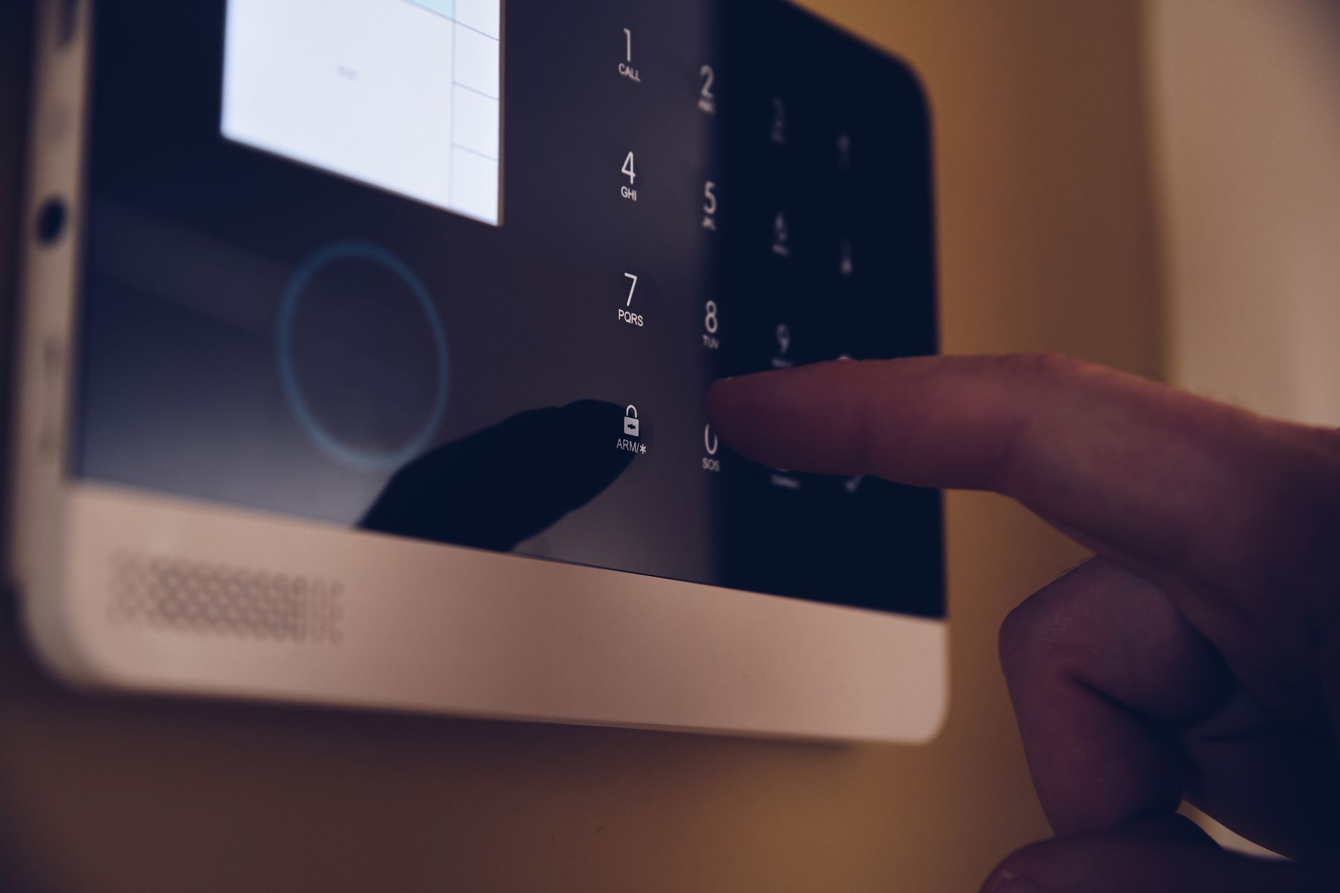 Hand holding a white card to a black card reader on a glass door
