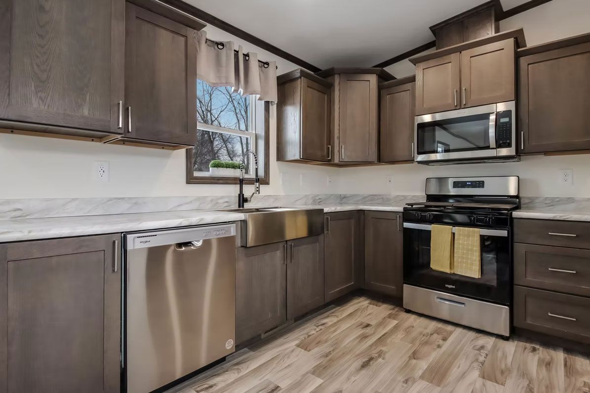 Modern kitchen with gray cabinets, stainless steel appliances, and a farmhouse sink.