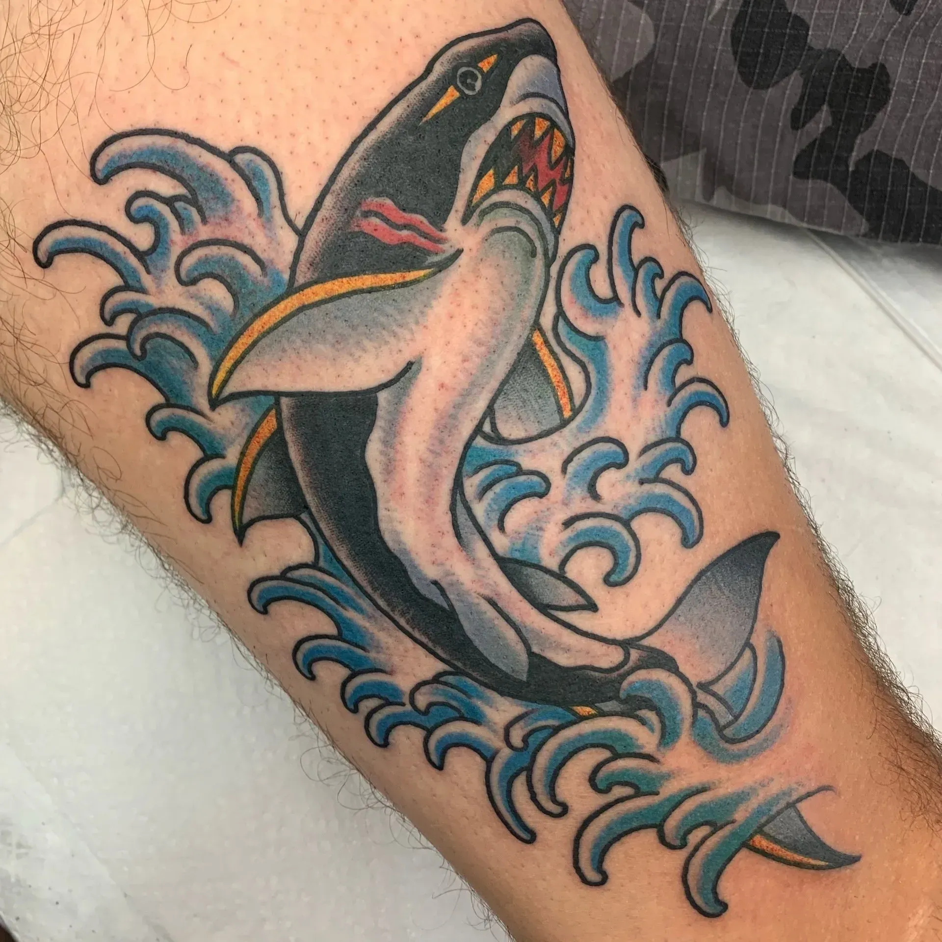 A tattoo of a shark jumping out of the water