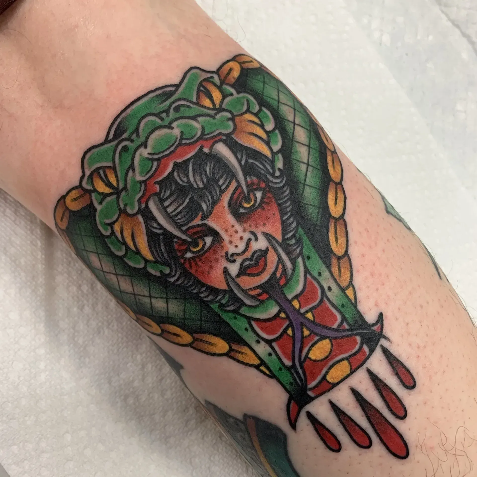 A tattoo of a woman with a snake around her head