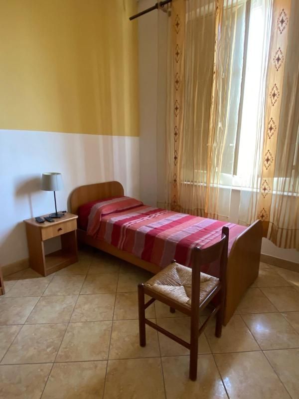 Una camera da letto con un letto singolo e una sedia