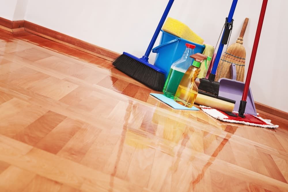 A Wooden Floor with Cleaning Supplies on It — Complete Clean Home Cleaning in Dapto, NSW