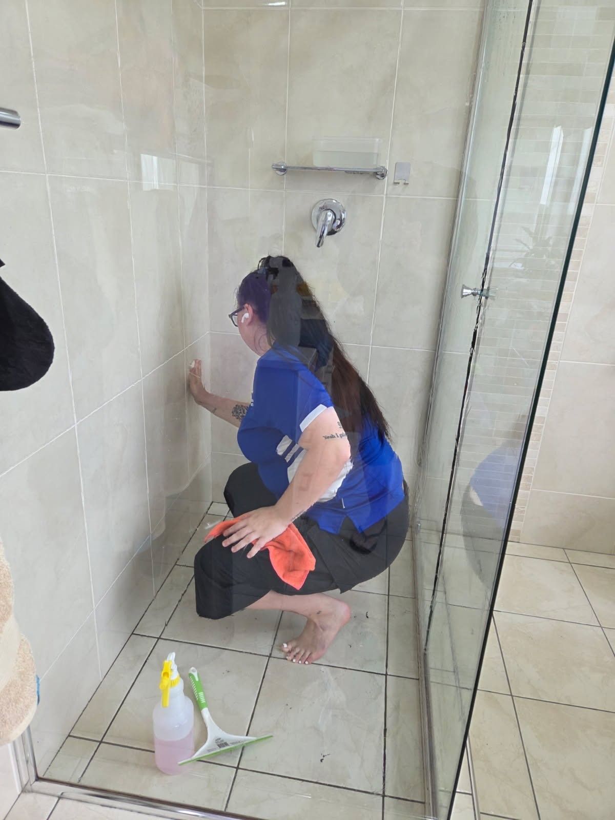 A Woman Is Cleaning a Computer Monitor in An Office — Complete Clean Home Cleaning in Shellharbour, NSW