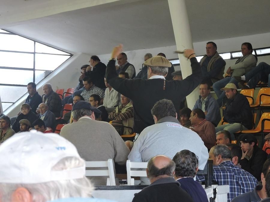 Un hombre con sombrero se encuentra frente a una multitud de personas.