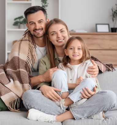 A woman is talking to a man and a woman while sitting at a table with a laptop.