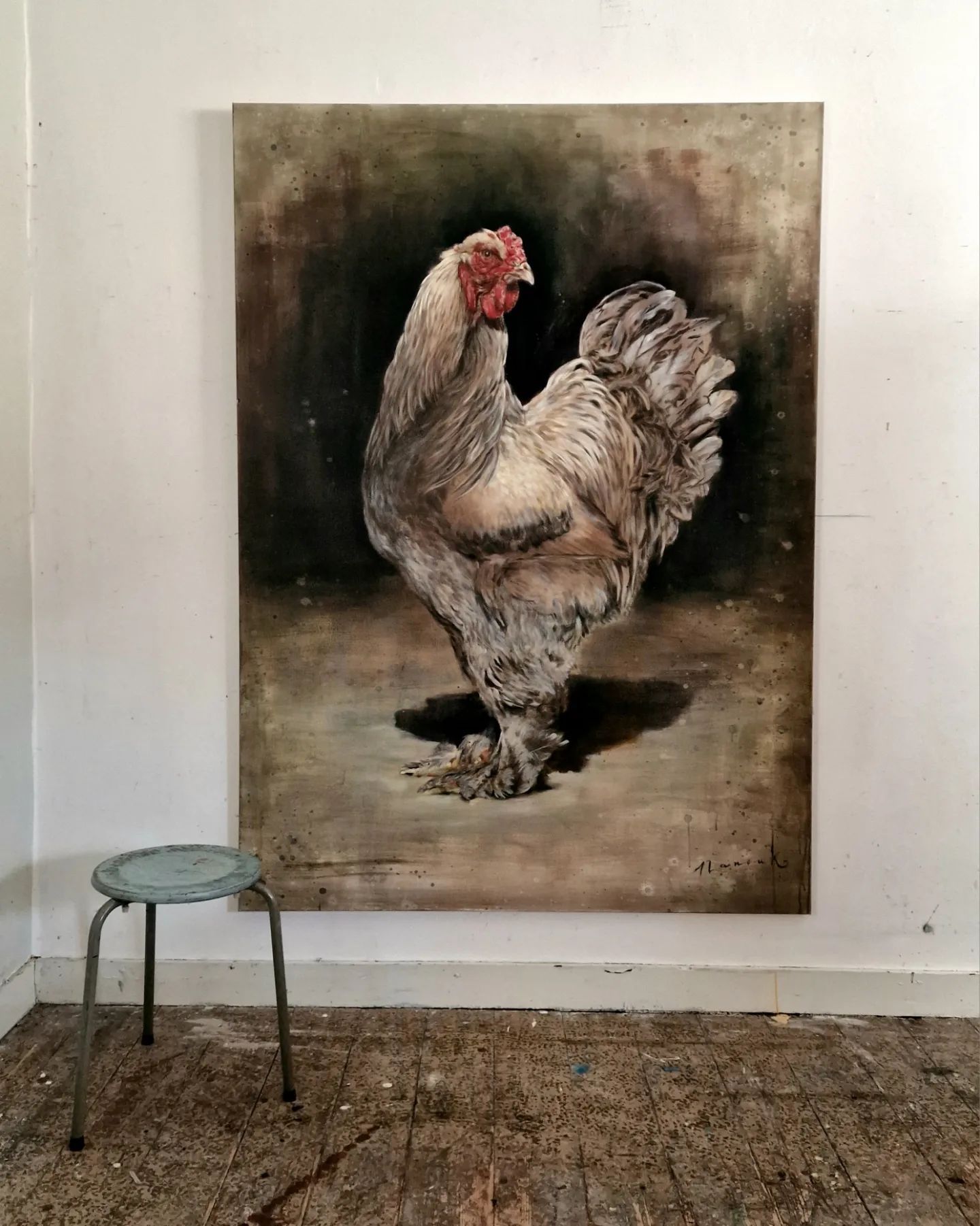 Een groot schilderij van een kip hangt aan de muur naast een kruk.