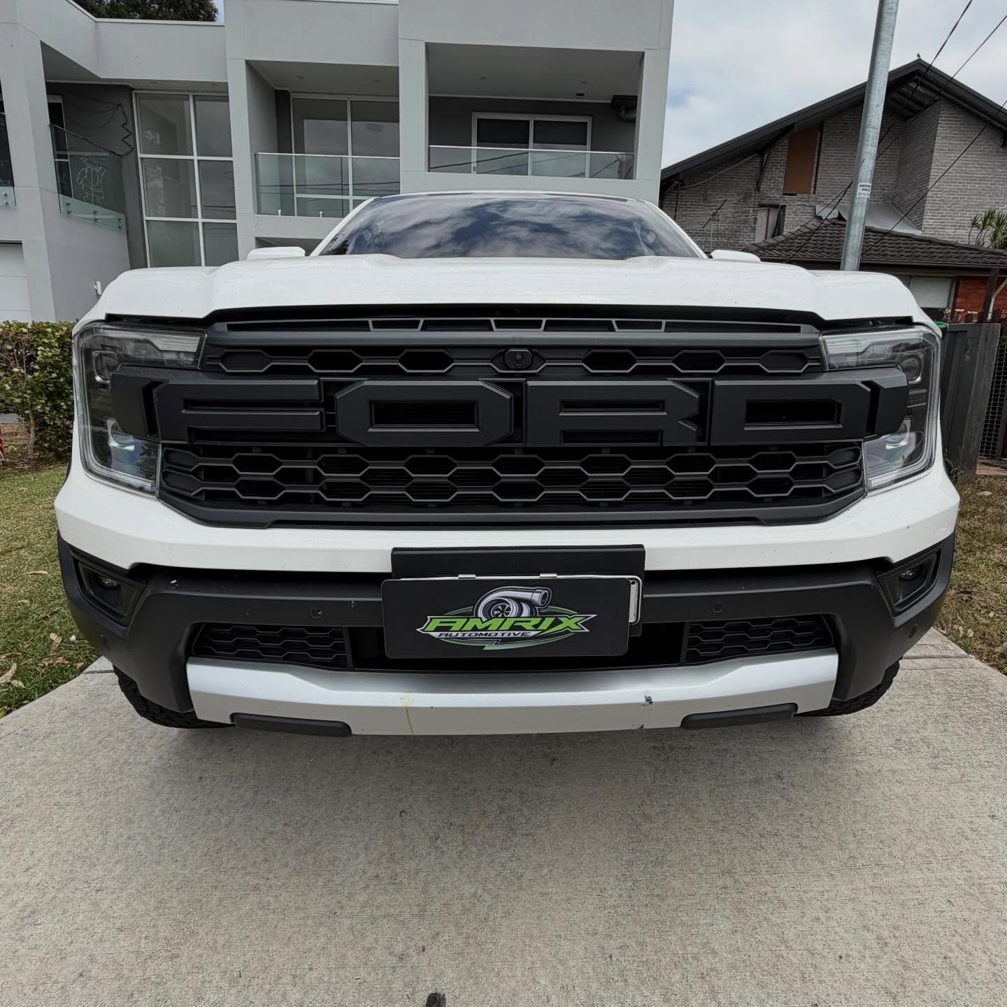 White Ford SUV with black grill and 