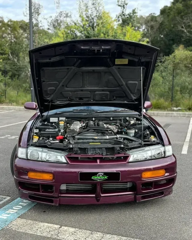 Dark purple Nissan S14 Silvia with hood open, parked in a lot — Amrix Automotive In Bankstown, NSW