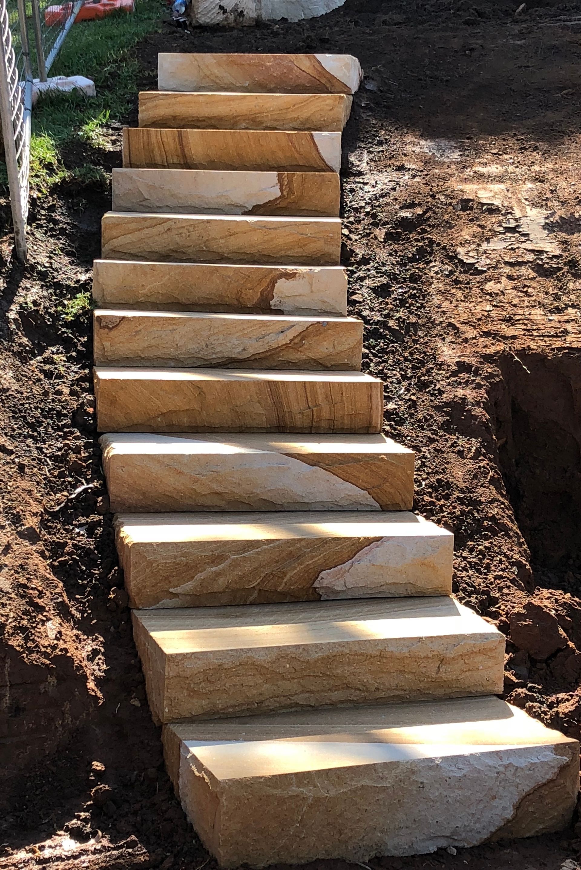 Stone steps built into a hillside, leading upwards.