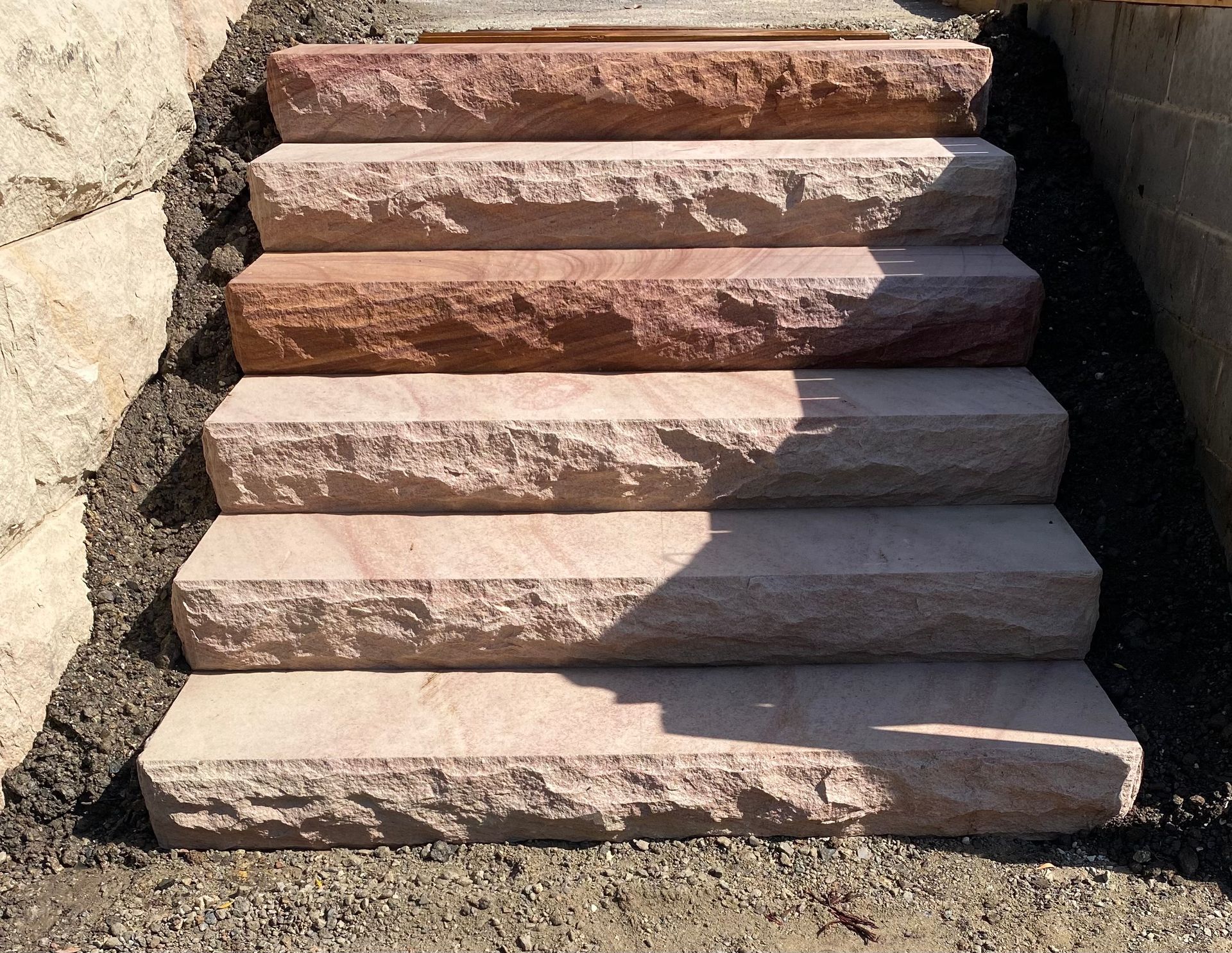 Stone steps leading upward, set into a hillside, with dark stone edging.