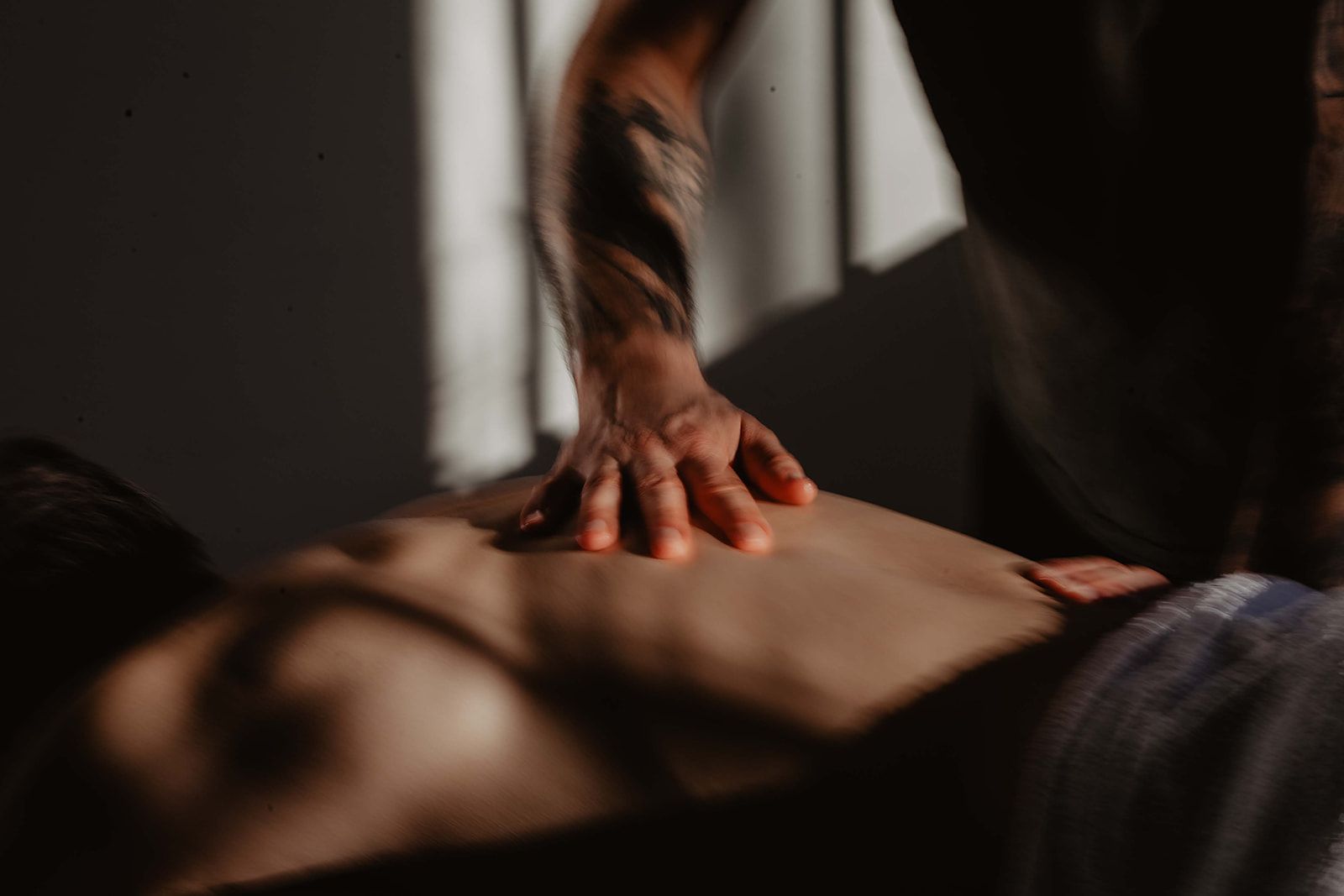 Een hand die een rug aan het masseren is. Met expertise in Shiatsu, Thaise massage en ontspanningsmassage. Gevestigd in Amsterdam; boekingsinformatie beschikbaar op de website.