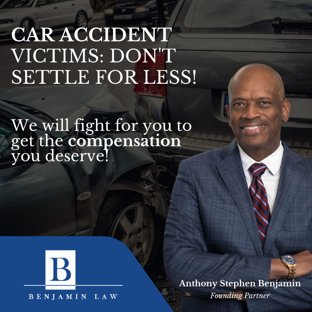 A man in a suit and tie is standing in front of a car accident.