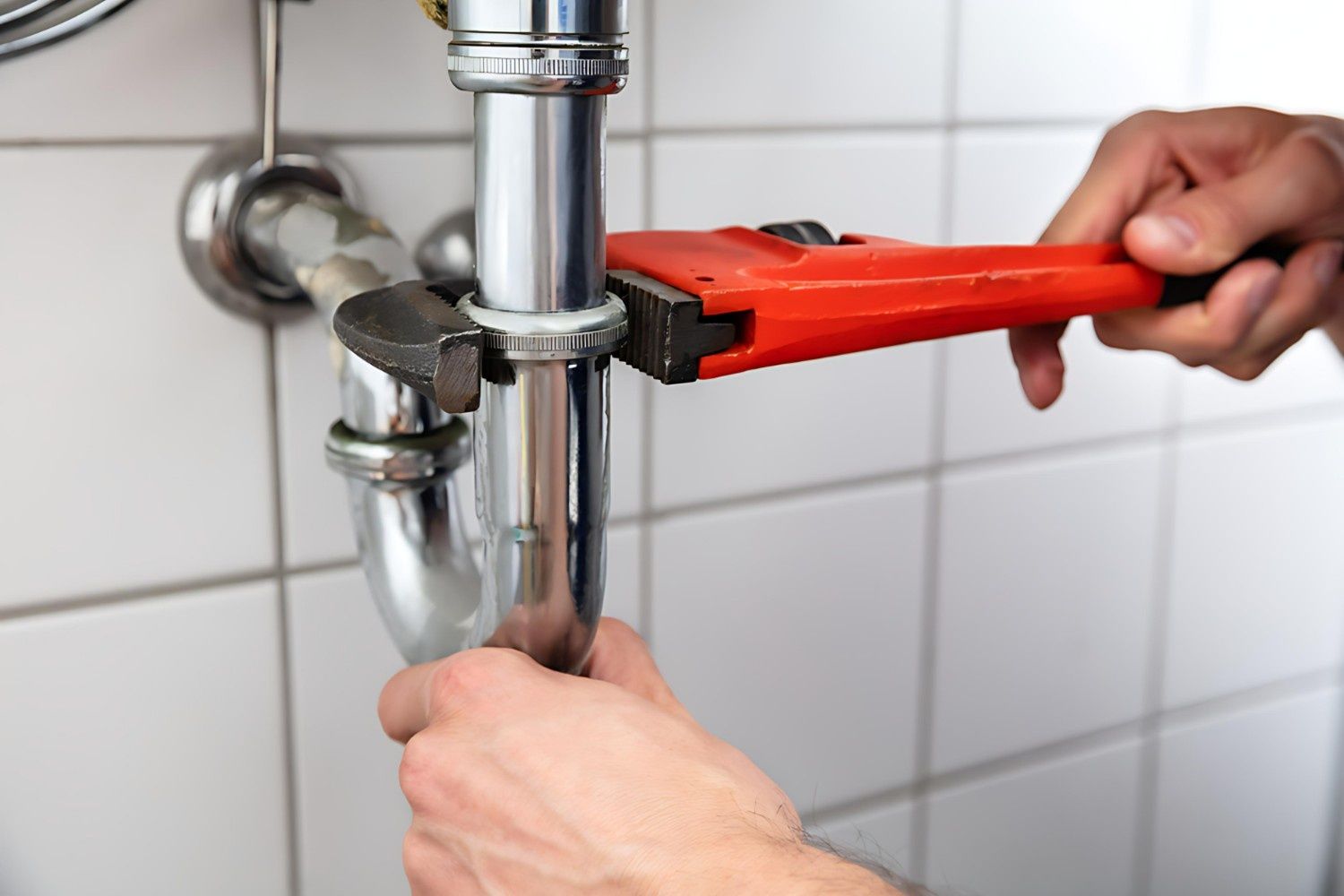 A Plumber Is Fixing a Sink Pipe with A Wrench — B3 Plumbing in Flynn, ACT