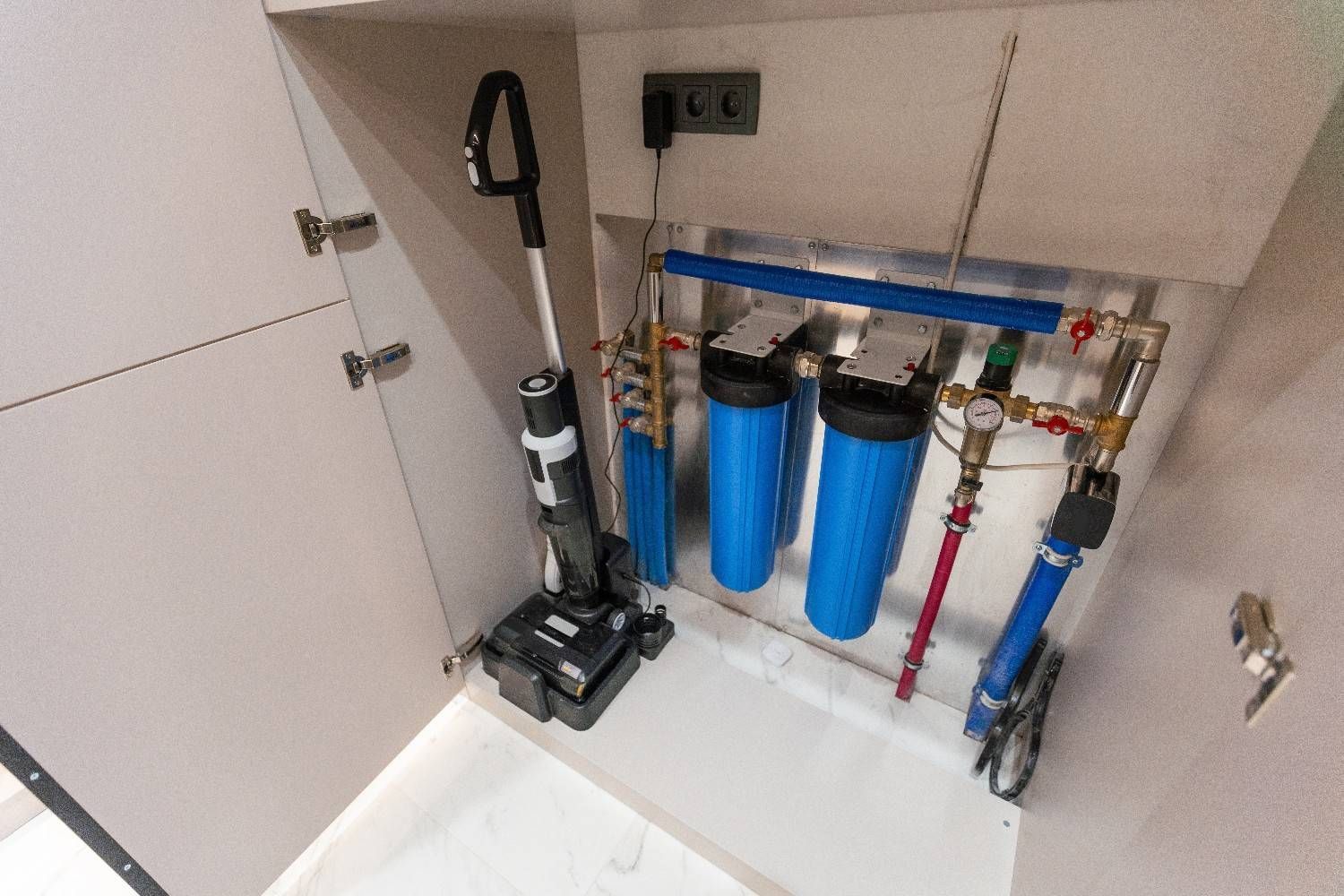 A Cleaner Is Sitting in A Cabinet Next to A Water Filter — B3 Plumbing in Flynn, ACT