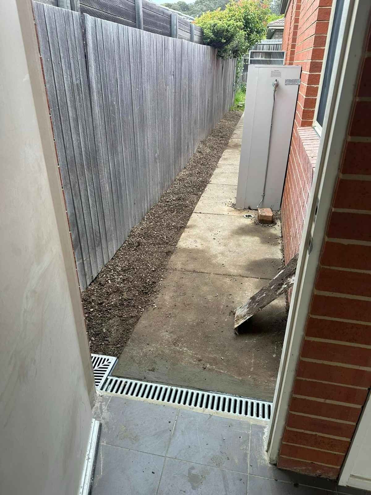 A Doorway Leading to A Sidewalk Next to A Fence — B3 Plumbing in Flynn, ACT