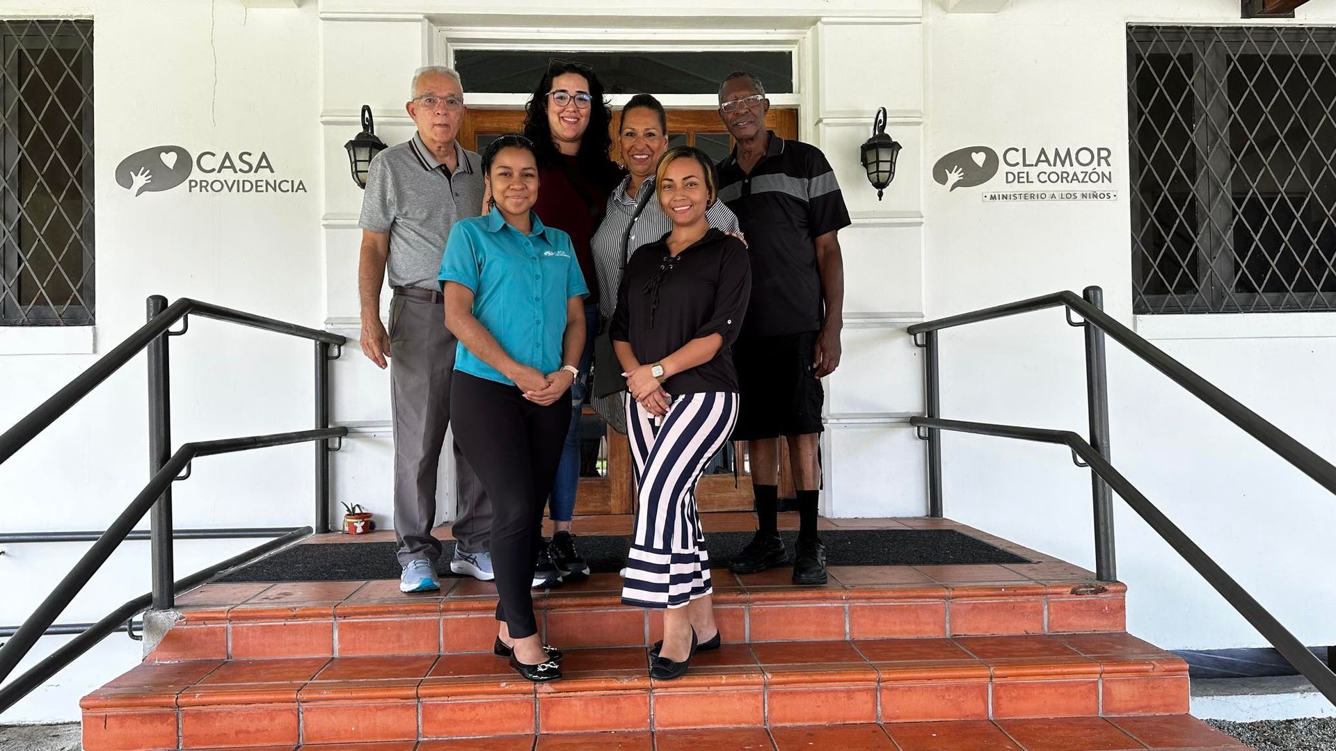 Group of people standing on the steps of a building with 