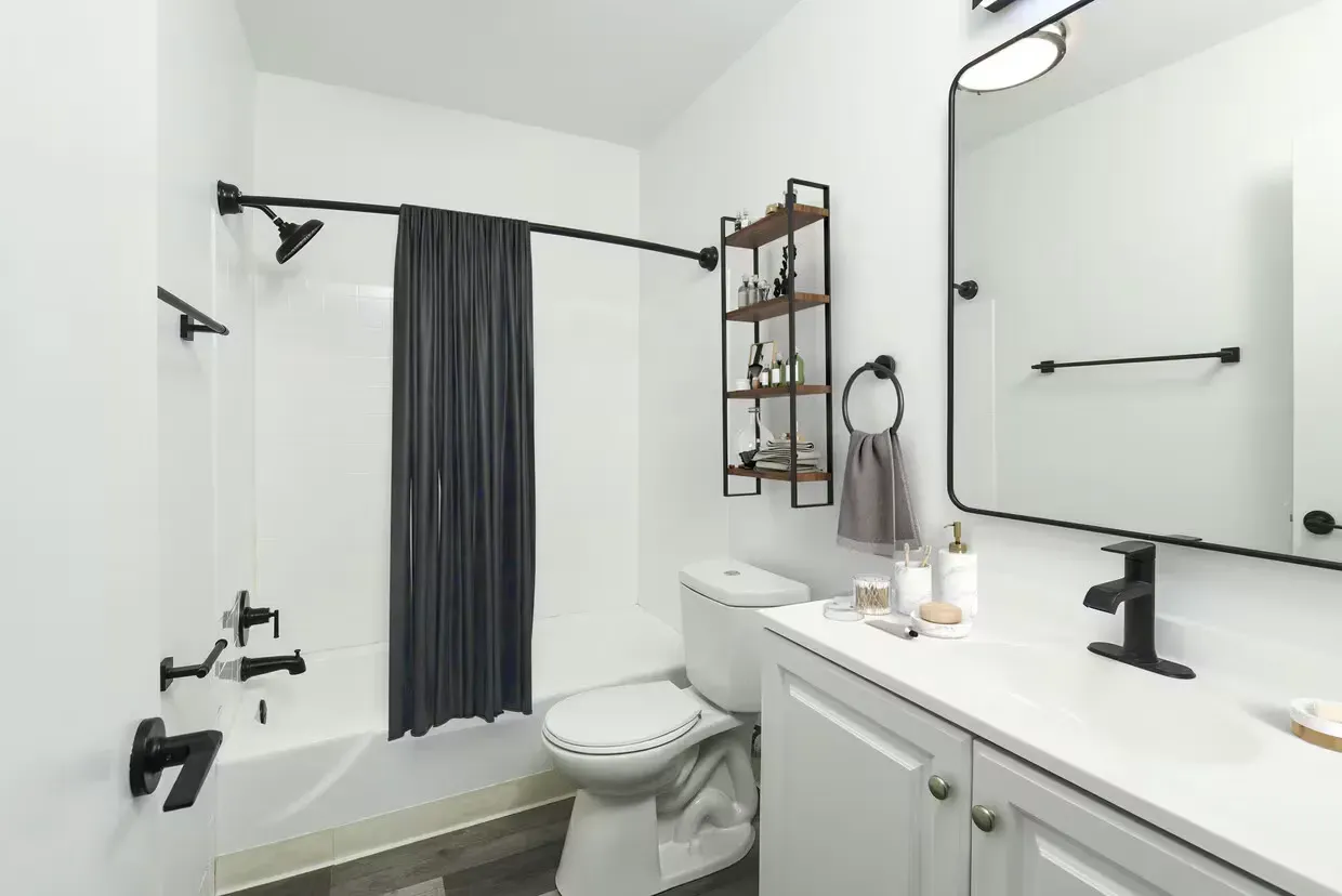 Modern apartment bathroom with white vanity, black fixtures, and a shower/tub combo at the Reserves at Arlington in Columbus, OH.