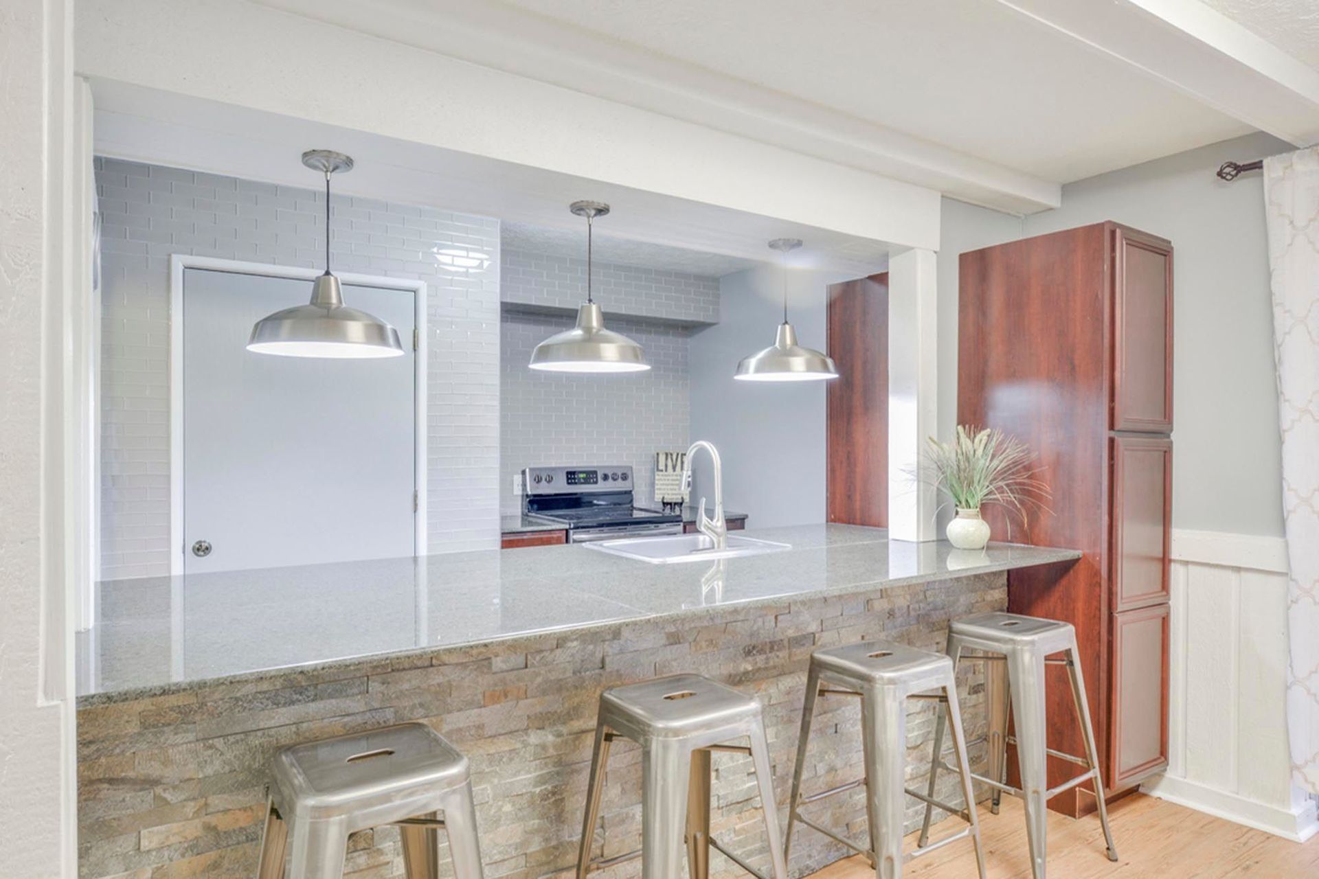 Modern kitchen with island, pendant lights, sink, and stainless appliances at the Reserves at Arlington in Columbus, OH.
