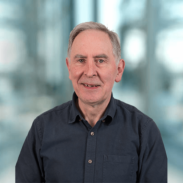 A man in a blue shirt is smiling for the camera.
