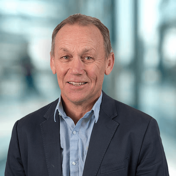 A man in a suit and blue shirt is smiling for the camera.