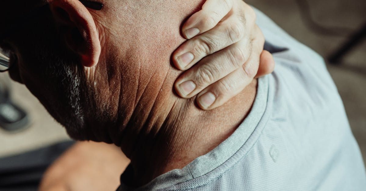 A man is holding his neck in pain.