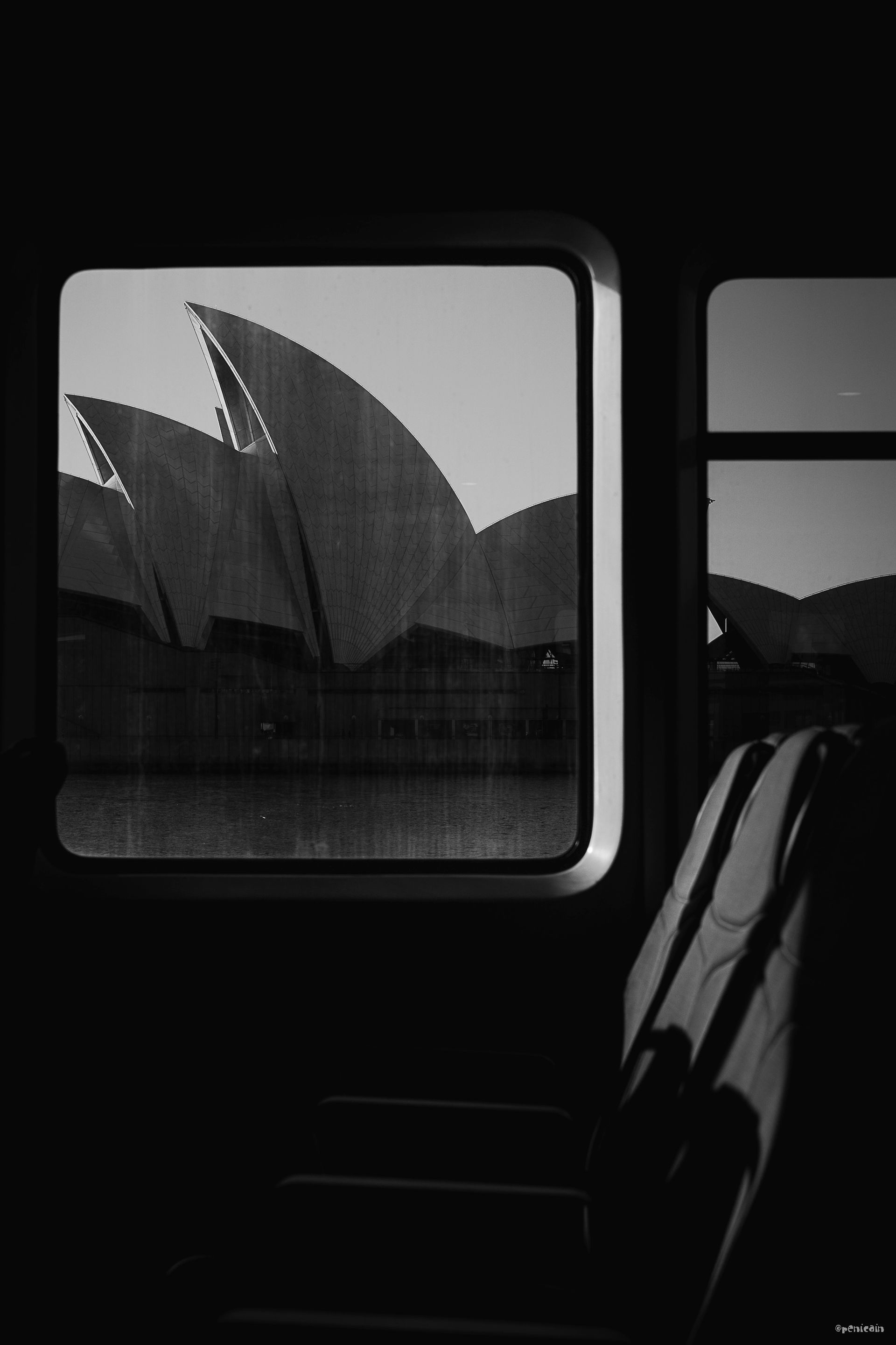 Sydney Opera House viewed from a train window, in black and white.
