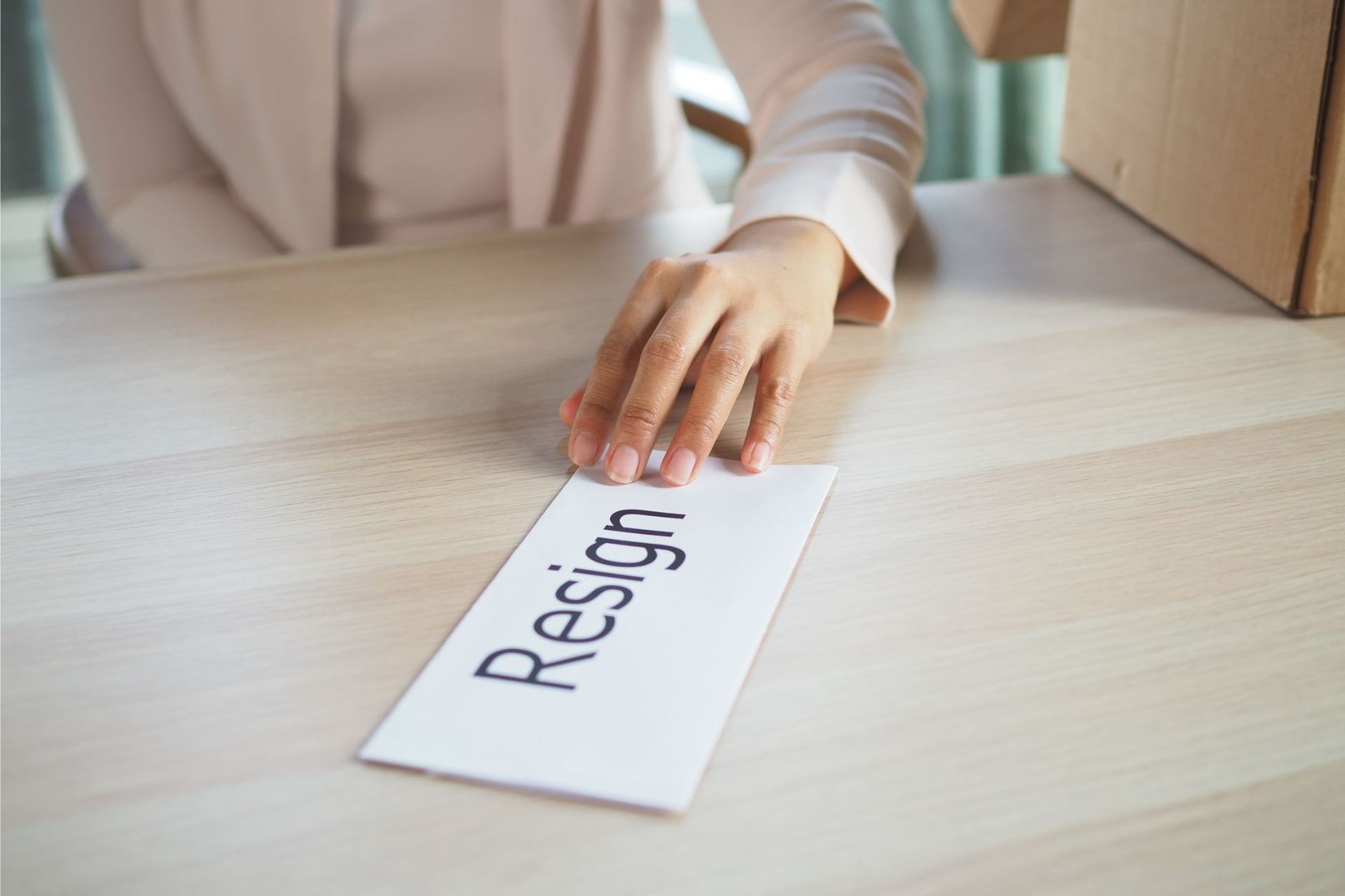 Person's hand reaching for a white card that reads 