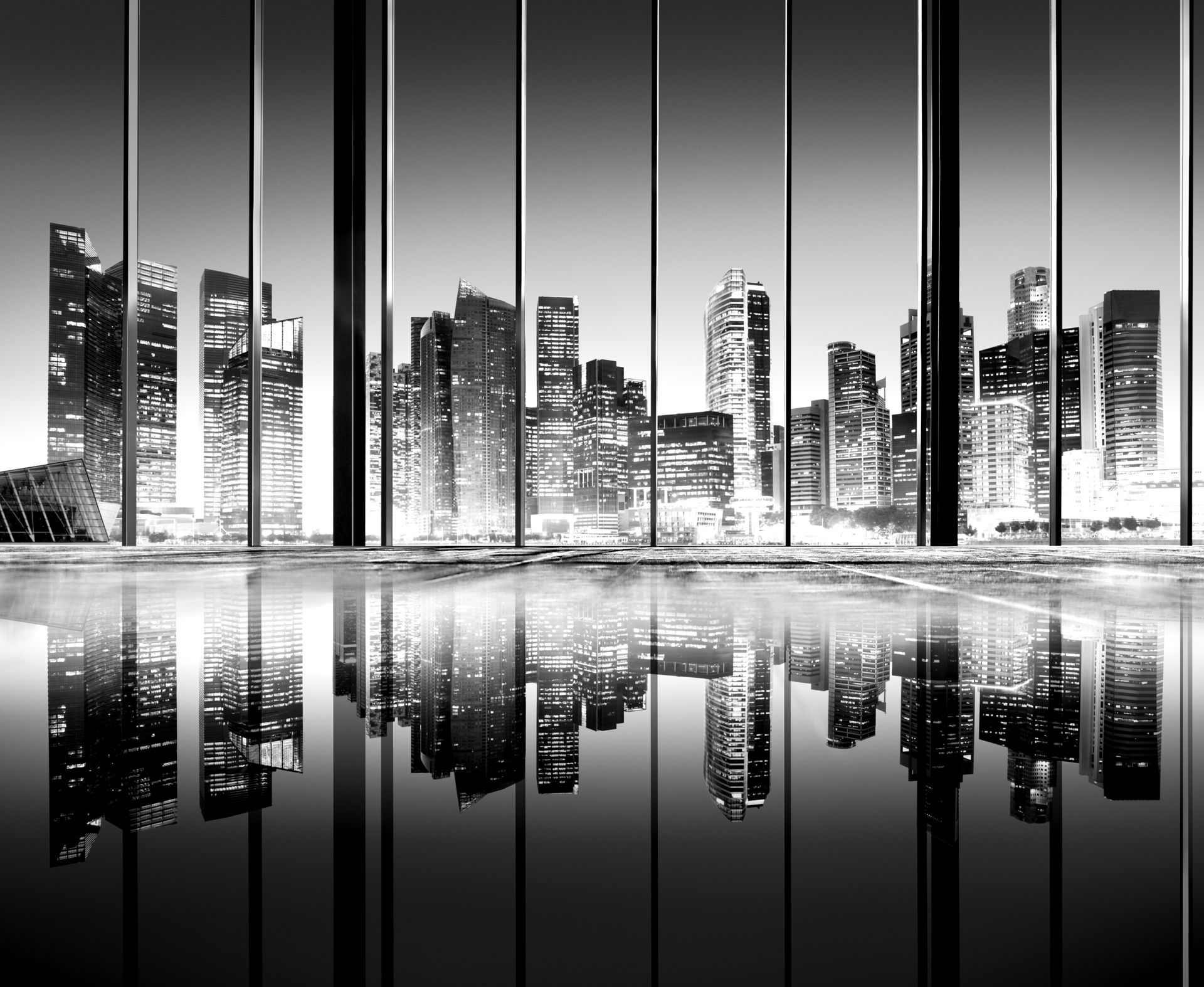 City skyline viewed through large windows, reflected in a shiny floor. Black and white.