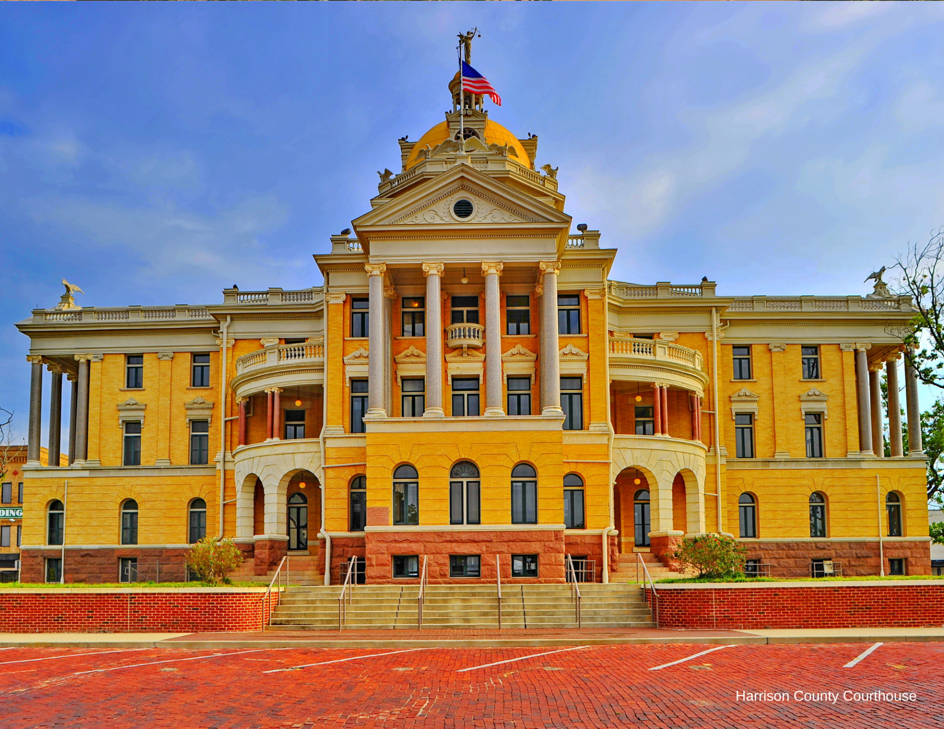 A large yellow building with an american flag on top