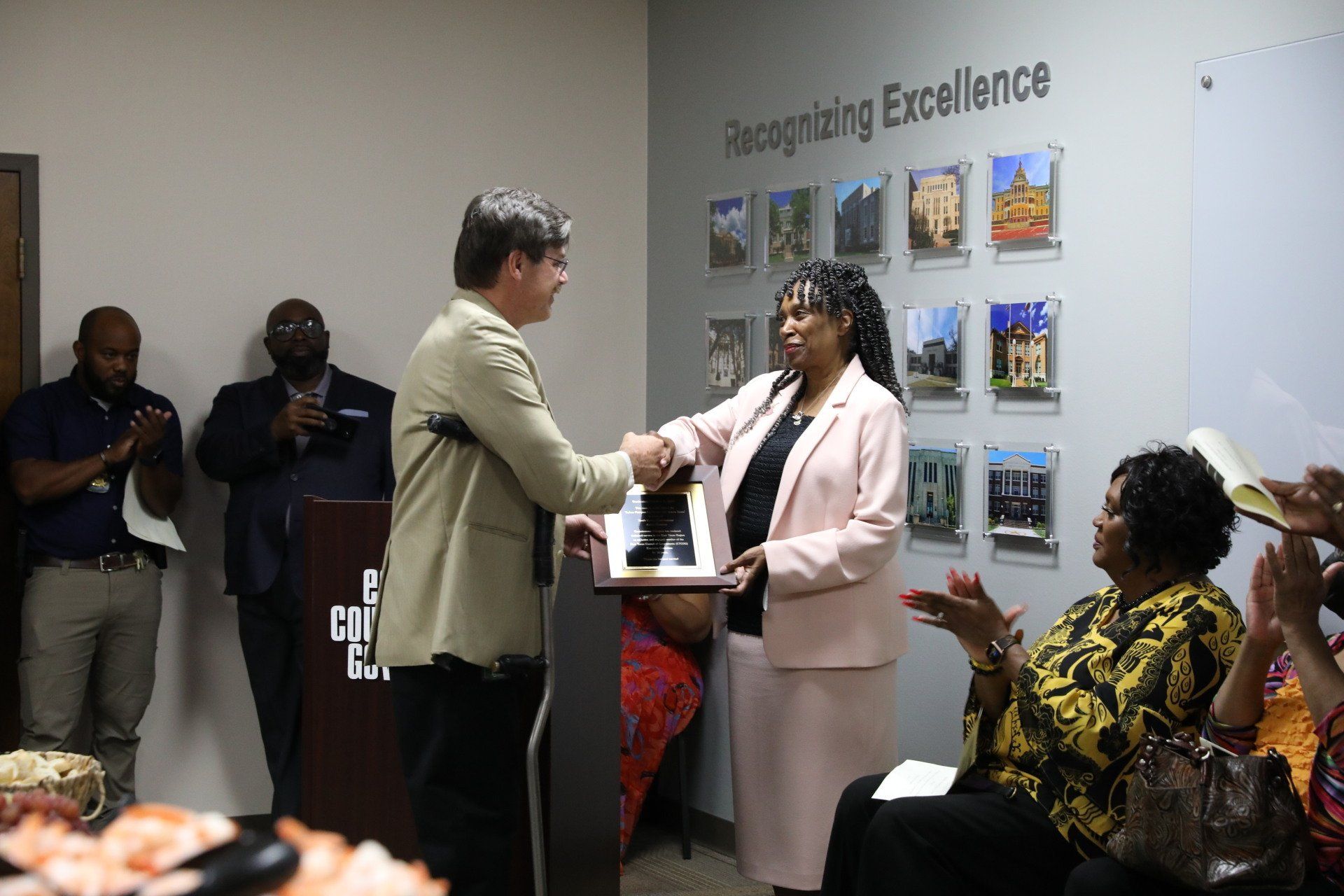 A man is shaking hands with a woman at a podium.