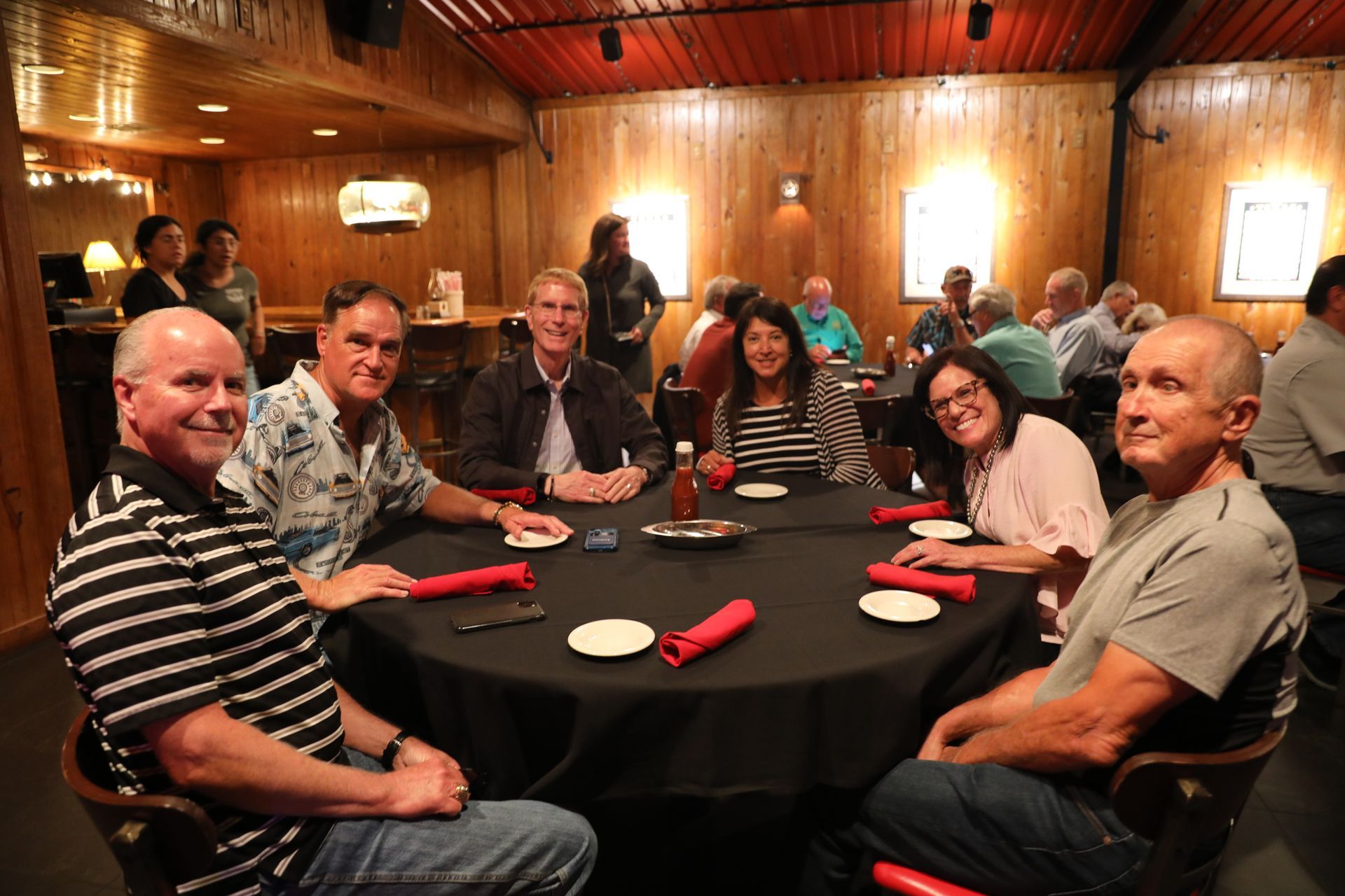 A group of people are sitting around a table in a restaurant.