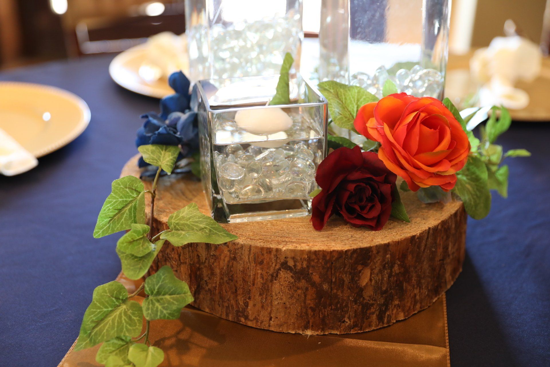 A wooden stump with a vase of water and flowers on top of it.