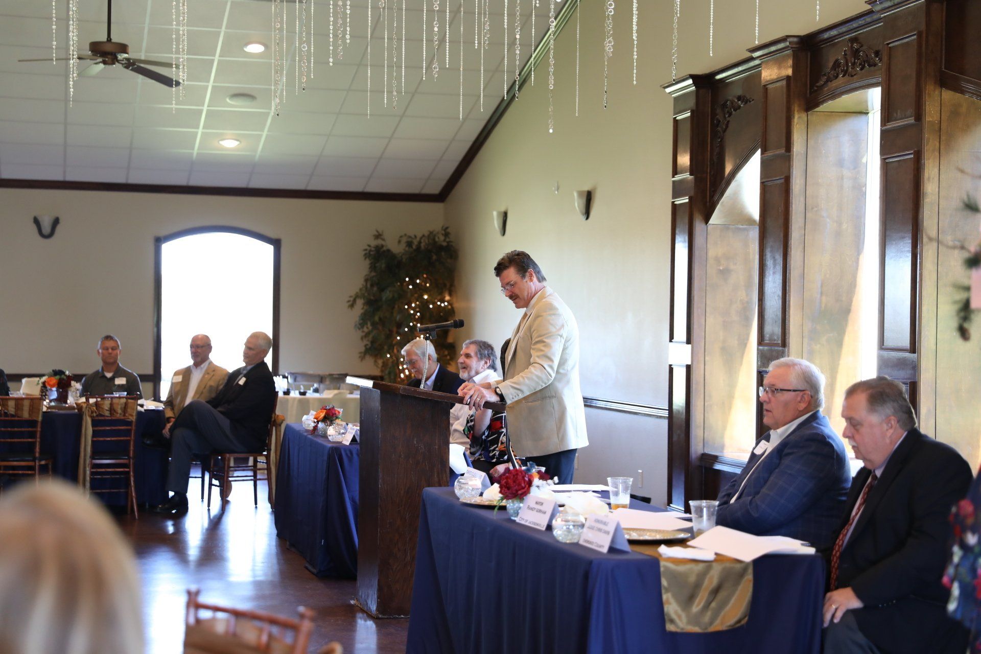 A man is giving a speech in front of a group of people