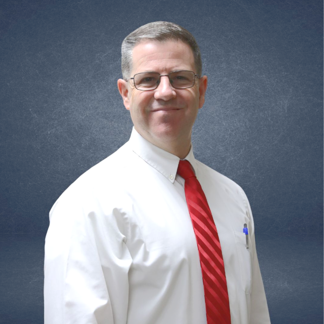 A man in a suit and tie is smiling for the camera.