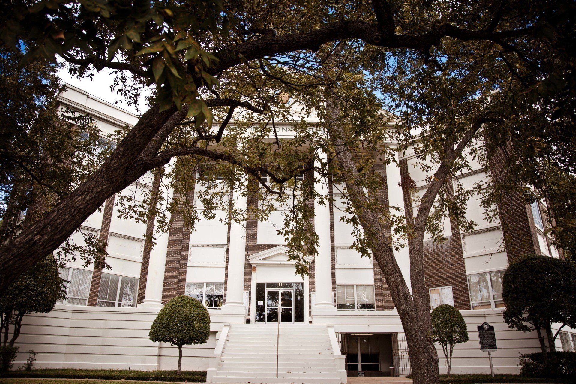A large white building with trees in front of it