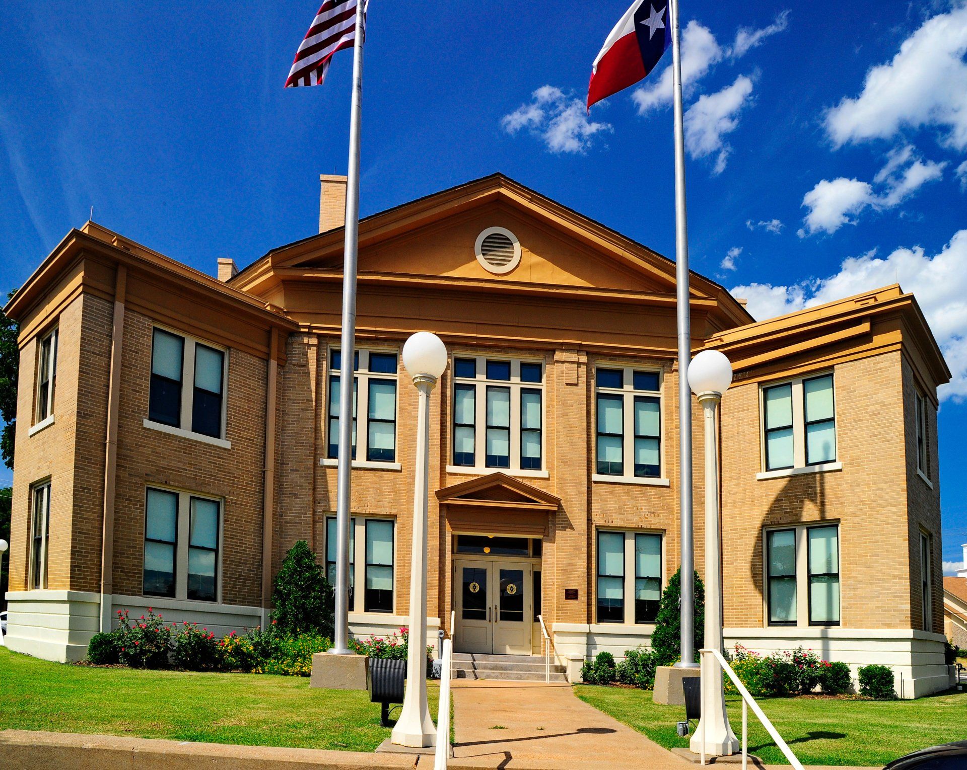 A large brick building with two flags in front of it