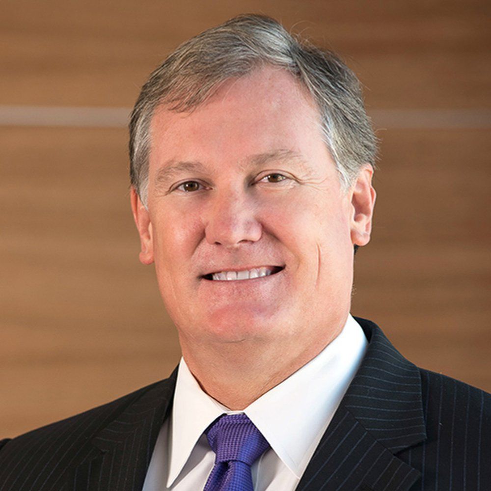 A man in a suit and tie is smiling for the camera