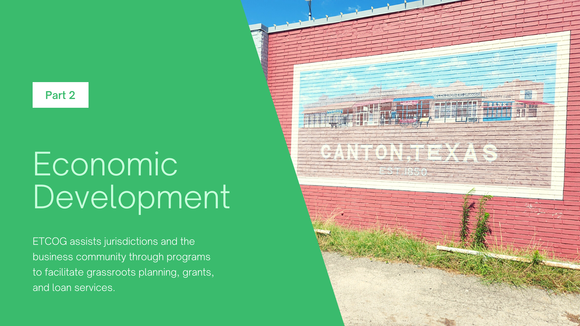 A red brick wall with a large billboard on it that says economic development.