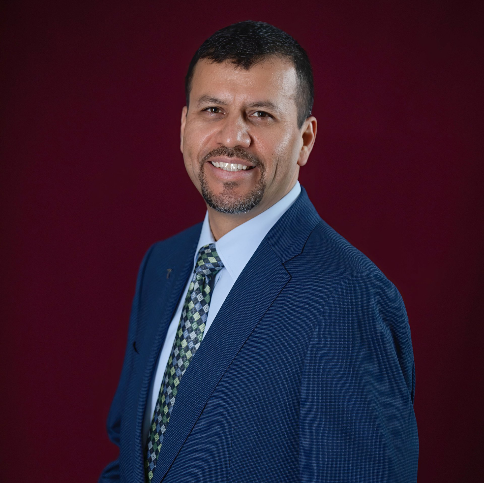 A man in a suit and tie is smiling for the camera.