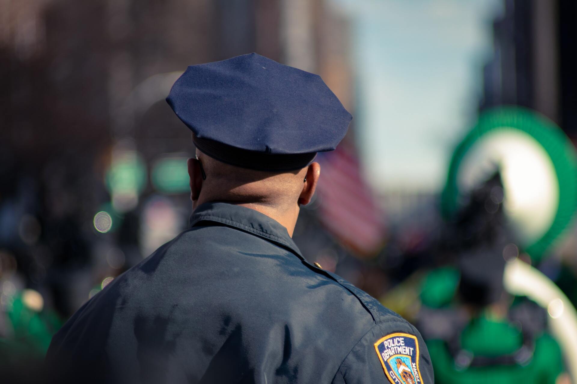 A police officer is standing in front of a crowd of people.