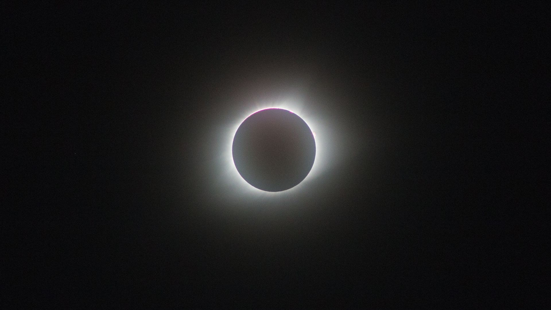 The moon is covering the sun during an eclipse.