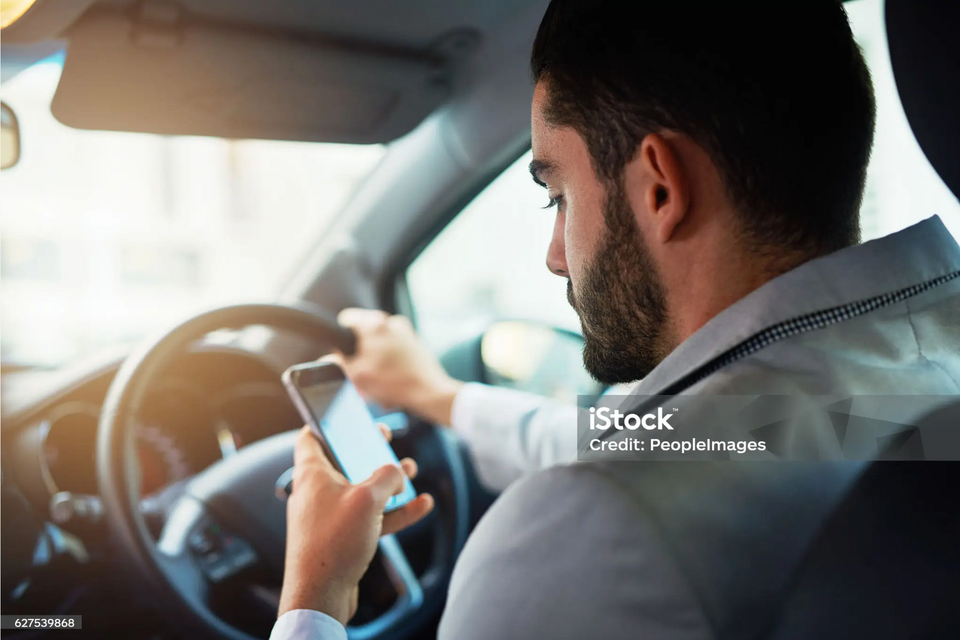 Driver using a smartphone behind the wheel.