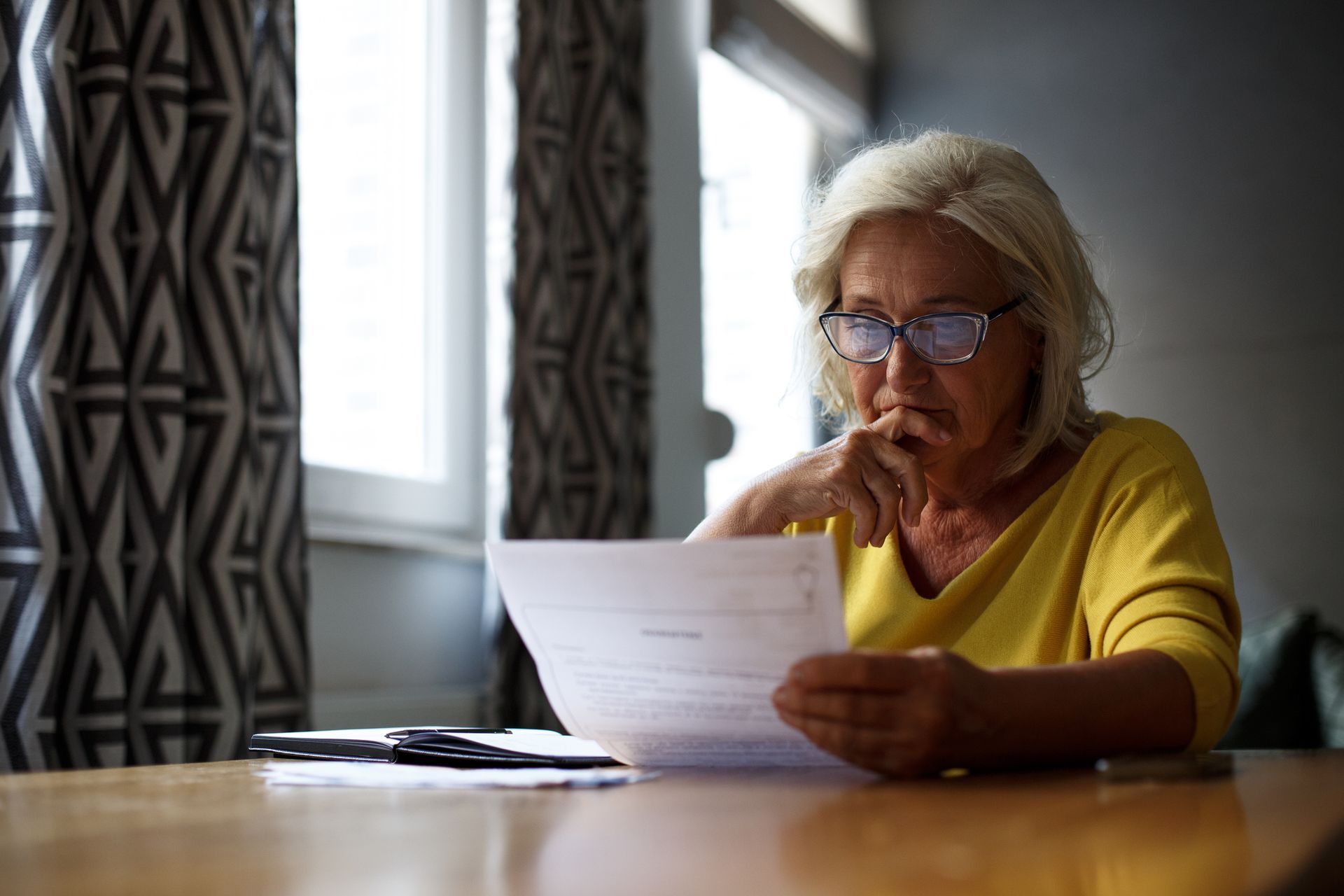 Concerned woman reading a long-term disability claim denial letter.