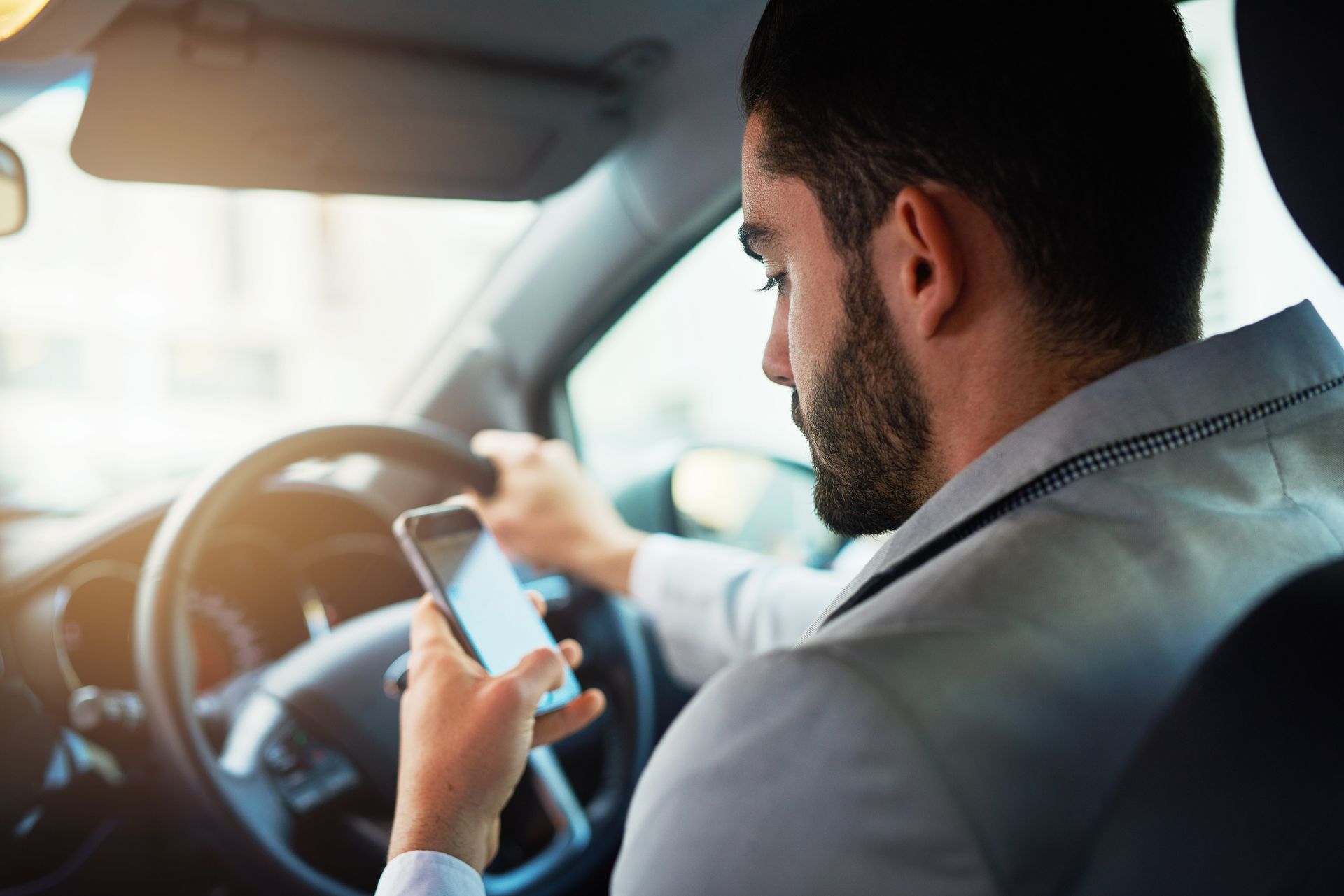 Driver using a smartphone behind the wheel.