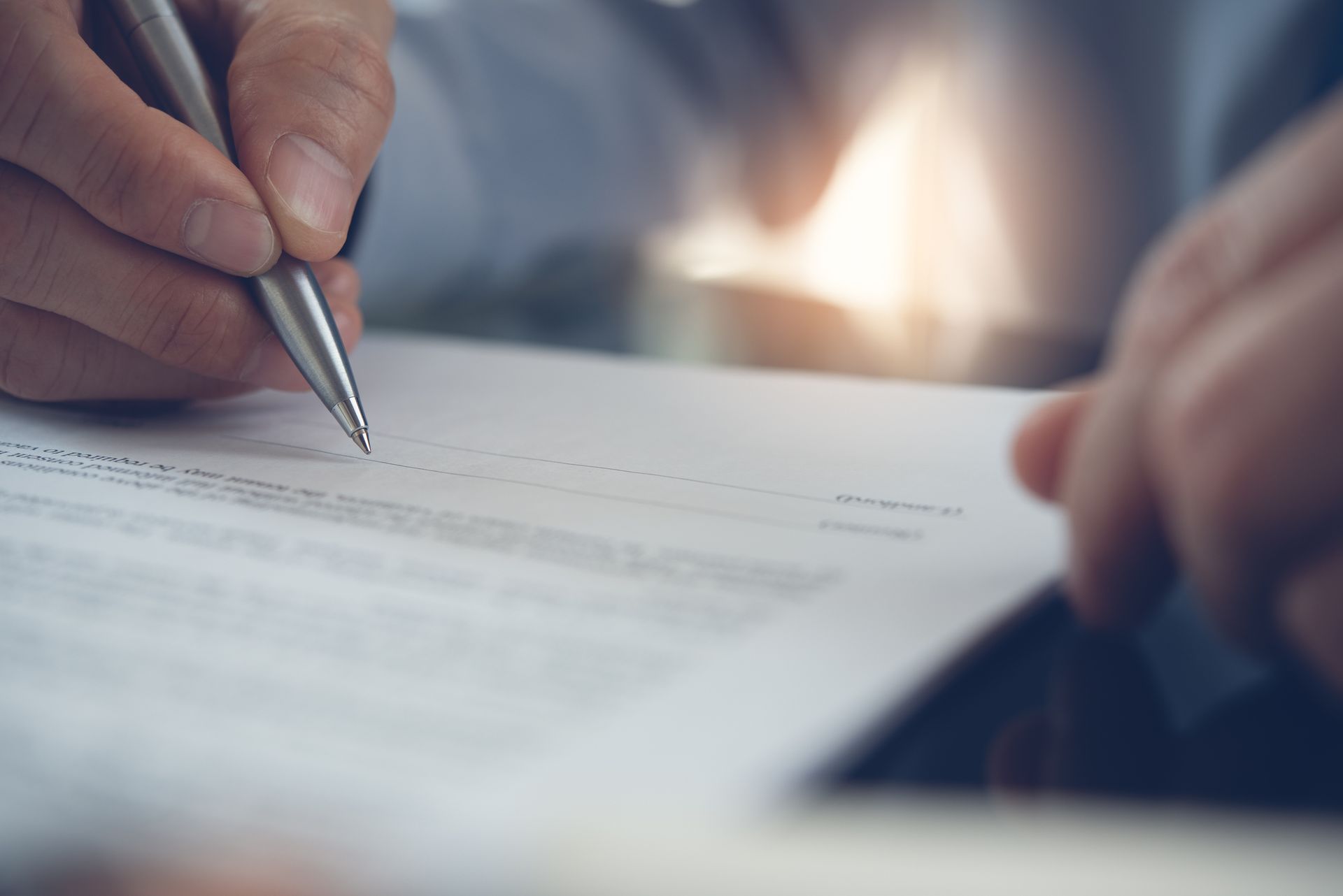 Close-up of a person signing an employment contract.