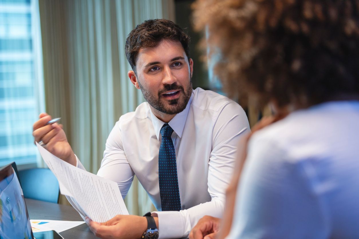 During a free consultation in an office setting, an employment lawyer provides guidance on legal documents to a client.