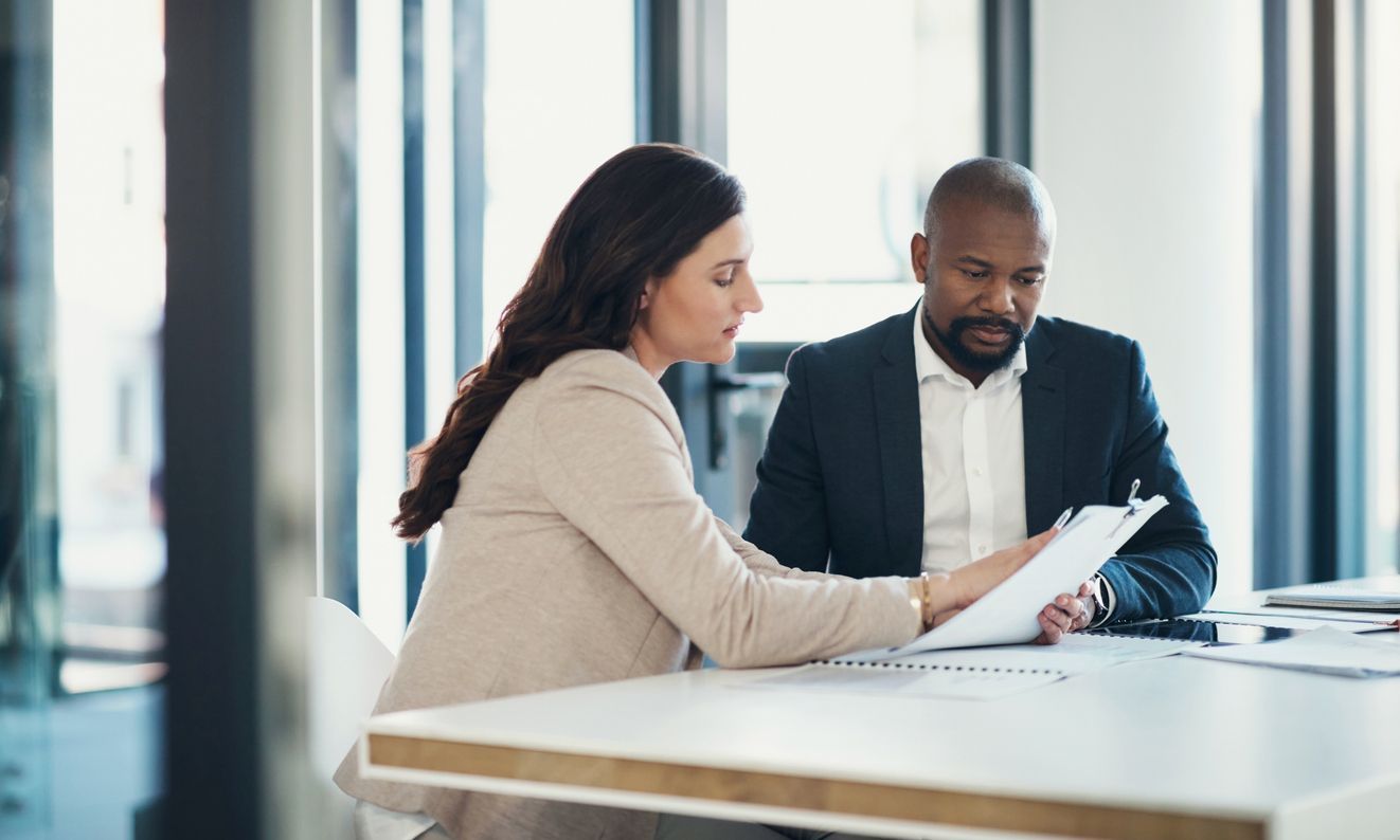 Professional consultation between a lawyer and a client in an office, reviewing legal documents.