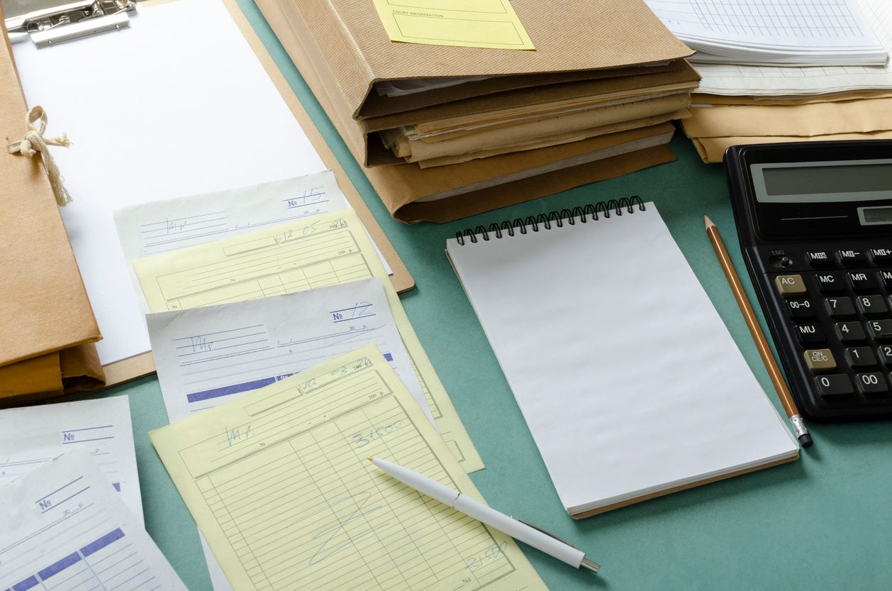 A notepad surrounded by documents, legal files, and a calculator, symbolizing preparation for a life insurance claim appeal.