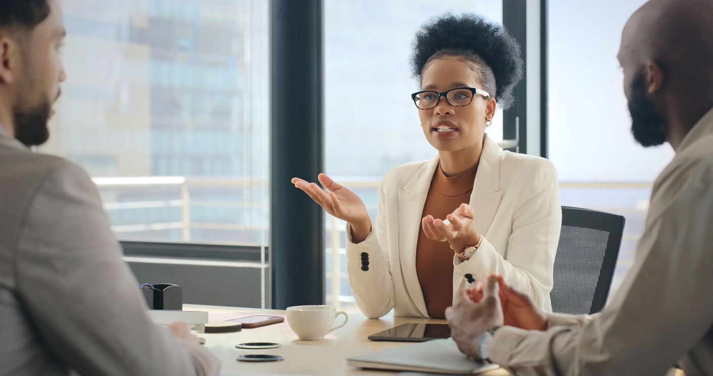 A professional life insurance lawyer, sitting at a desk in an office setting,  discusses claim options with two clients.